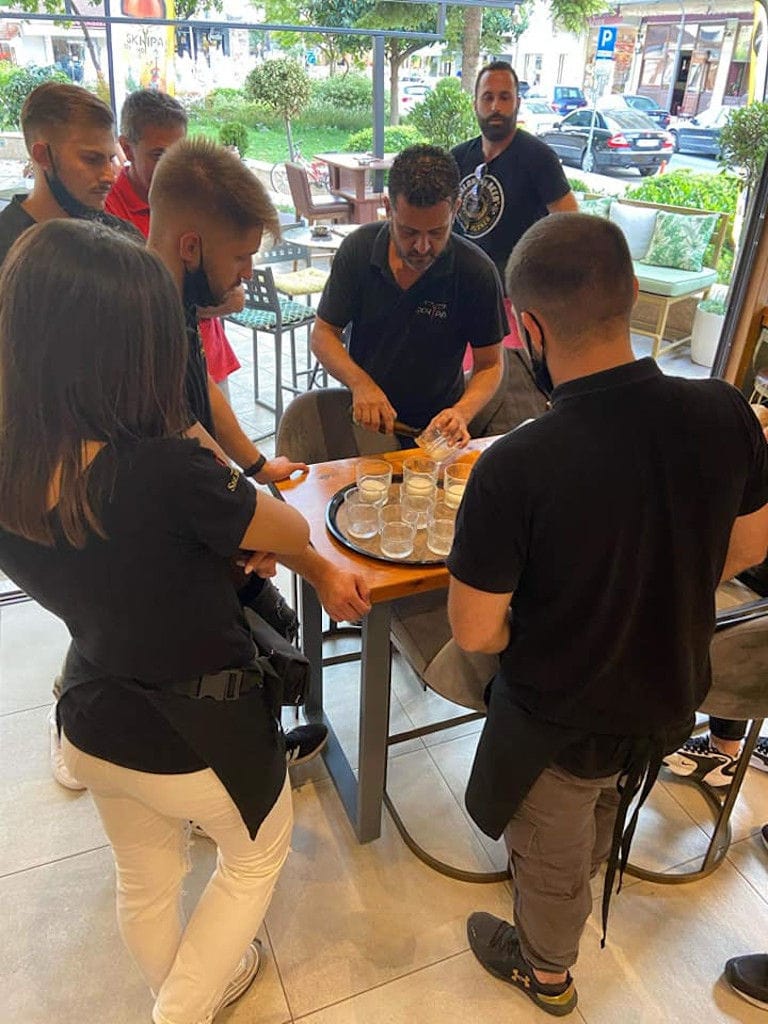 man pouring beer in glasses from the bottle at 'Sknipa' and tourists waiting to taste it